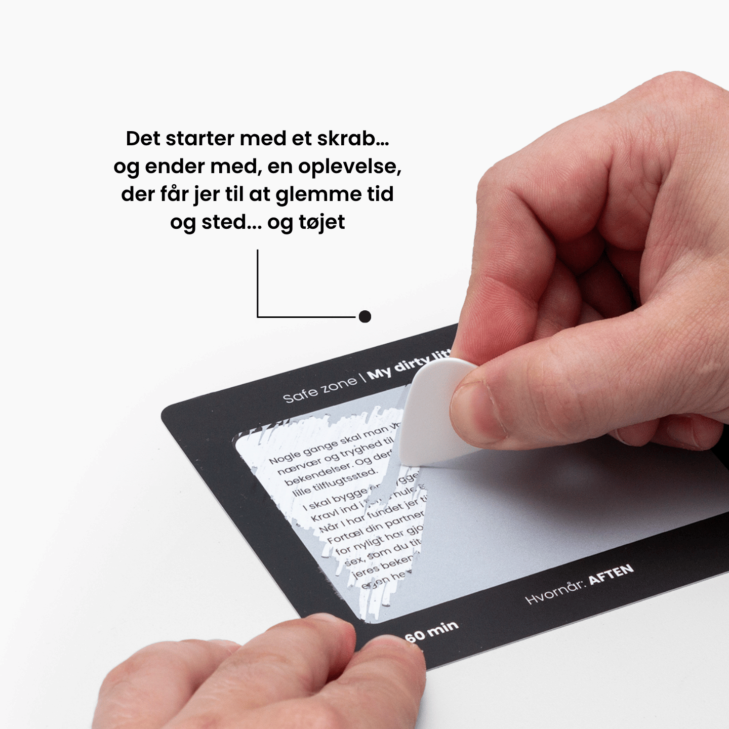 Hånd der skraber et kort fra SkjulteOplevelser™ – Under Lagnerne, et frækt parspil med scratch-off udfordringer, der fører til intime og sjove oplevelser sammen.